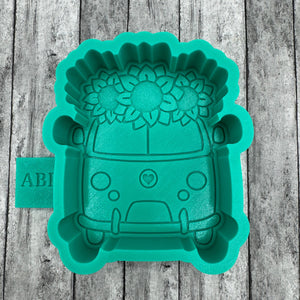 Green silicone mold shaped like a car on a wooden surface