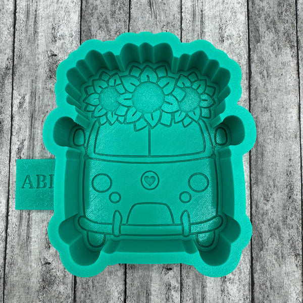 Green silicone mold shaped like a car on a wooden surface
